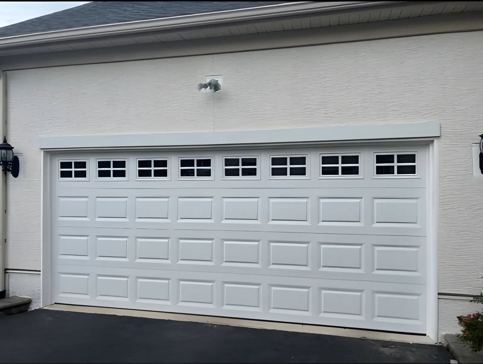 White double-width raised-panel garage door with a row of square windows